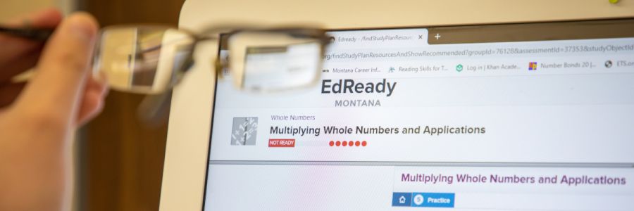 eyeglasses being held up to a computer screen with the EdReady website on it