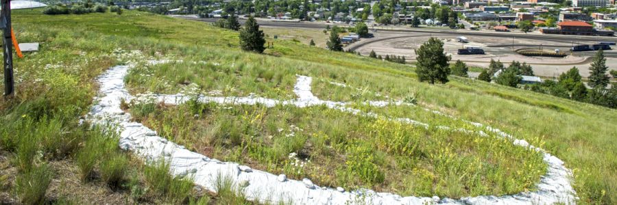 painted peace sign on a Missoula mountain viewed from above it