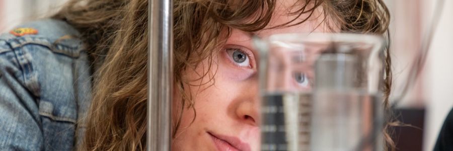 student looking into a beaker filled with water