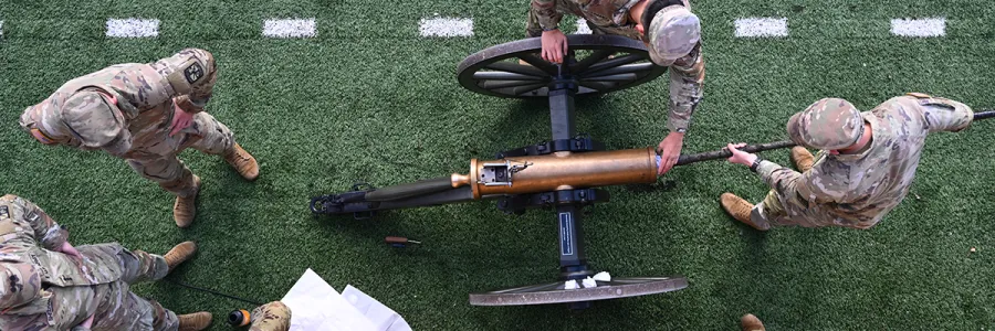 An aerial view of the UM ROTC Boom Crew members in uniform loading the cannon at a football game in Washington-Grizzly Stadium in Missoula, Montana.
