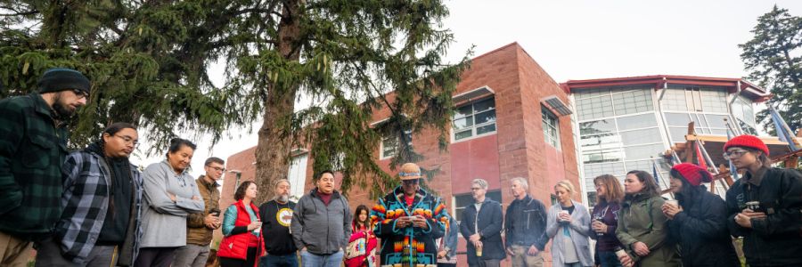 people standing a circle watching a presentation outside of the Payne Family Native American Center