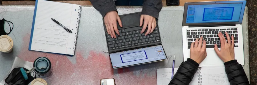 Two students work on laptops in the University Center