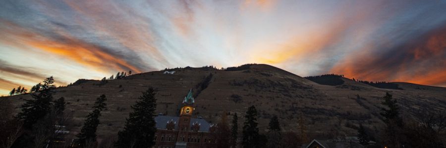 University Hall with clock lit up and Mount Sentinel under a dramatic cloud filled sky