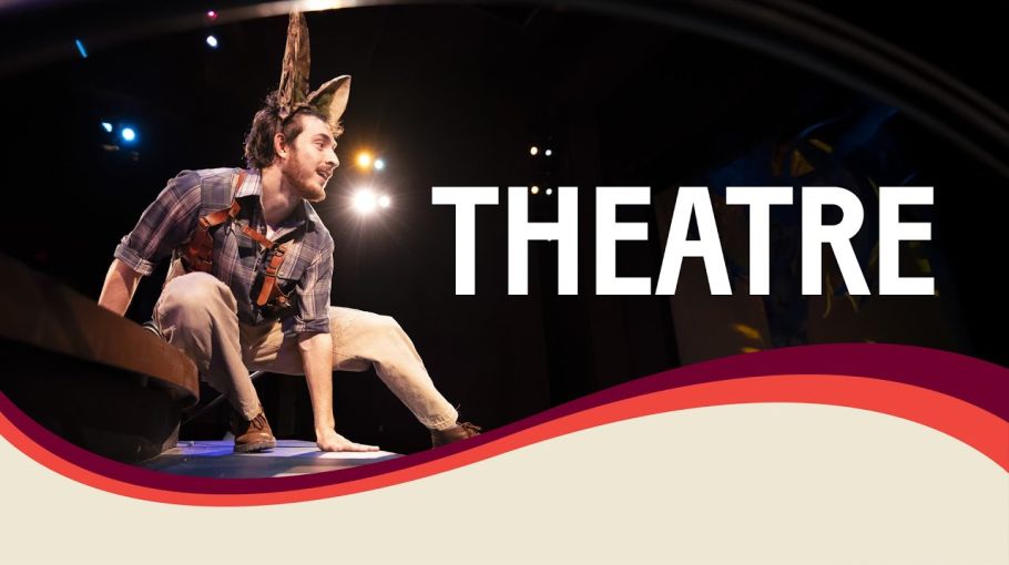 A UM student in costume performs on stage. The word THEATRE appears on screen