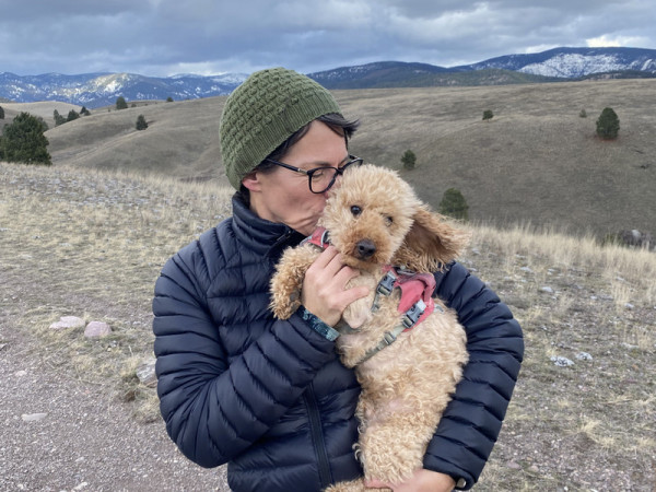 Naomi DeMarinis cuddling her dog on a trail near Missoula.