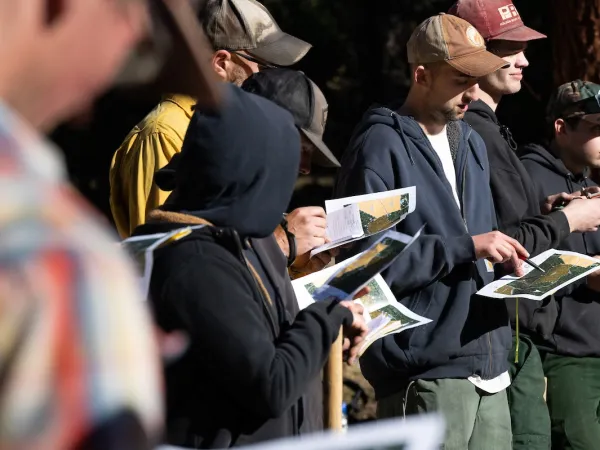 UM students standing and examining maps during a class at University of Montana's Lubrecht Experimental Forest, north of Missoula, MT.