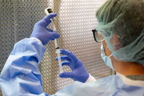 Person putting drugs into a syringe 