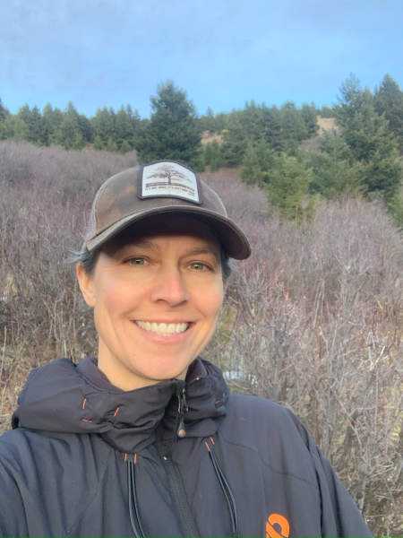 Jennifer Jones smiles brightly in a wheat-colored prairie.