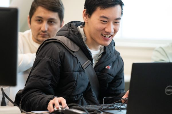 student sitting at computer smiling