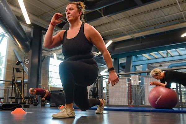 A woman doing a lunge in her living room.