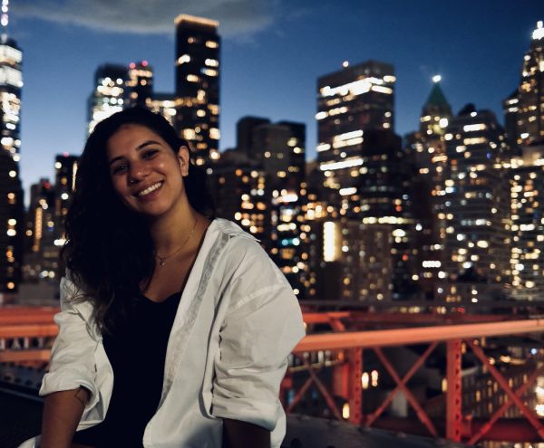 Ana Carolina Grizoni Elias standing in front of a city skyline at night