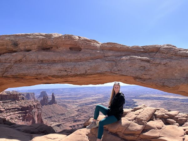 Anna Reszewicz sitting on a rock formation