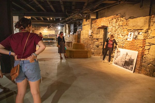 a tour guide in missoula's underground points out a piece of a picture and speaks 