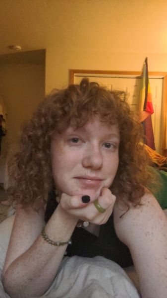 An image of Maggie Watts leaning on her hand smiling