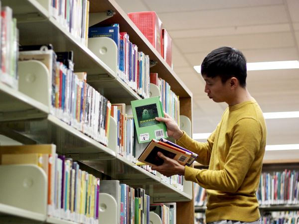  a man reading books in a library
