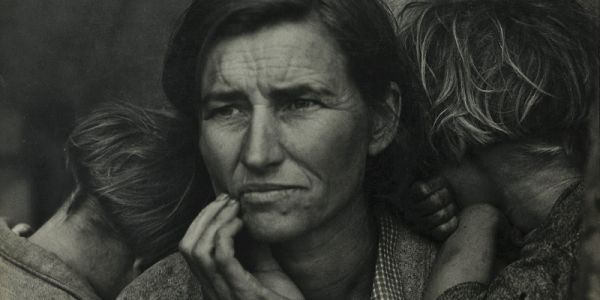 black and white photo of a woman looking into the distance  with two kids one on each shoulder faces down