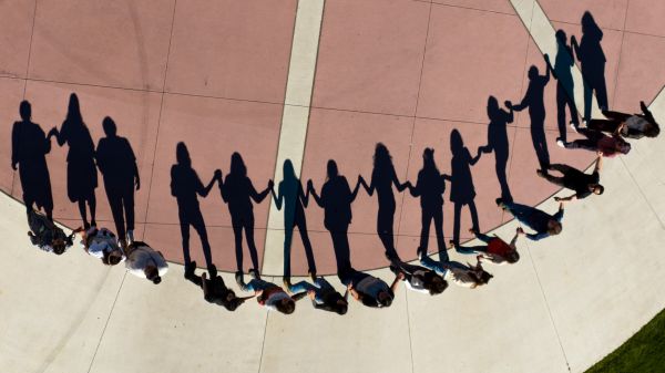 Arial view from above a round dance on the oval. where the sun cast shadows of the dancers