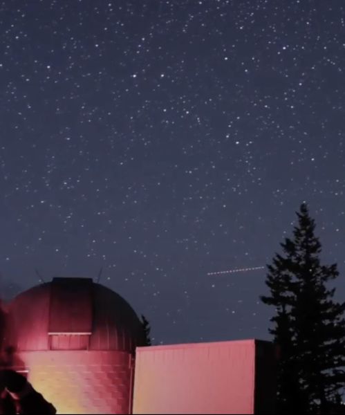 blue mountain observatory outlined against a night sky