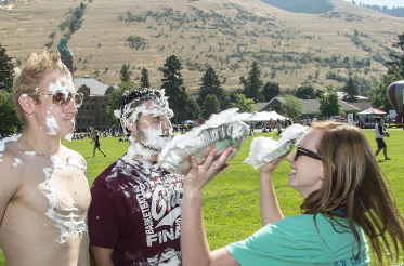 a girl throw pies in the face of two guys