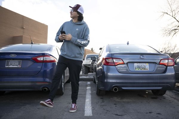 male student walking away from their car in the parking spot