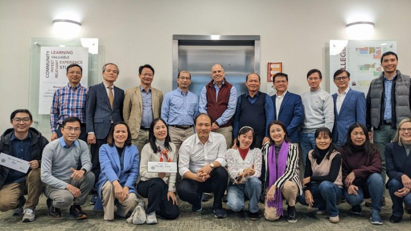 Group photo of a diverse team of professionals gathered in an office setting
