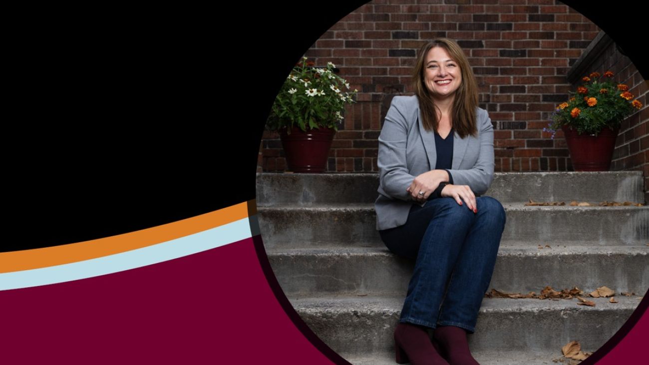 Jenny Petty seated on stairs with UM brand wave in background