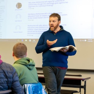 A faculty member delivers a lecture to students