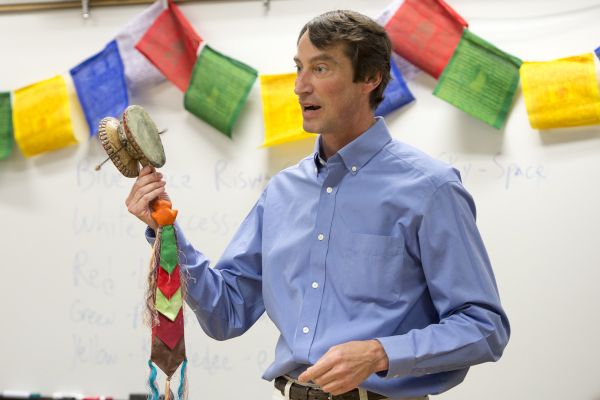 Male teacher in front of whiteboard with cultural banner
