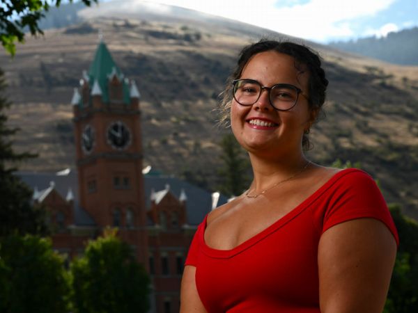 UM graduate Ava Heintzelman poses for a photo in front of Main Hall at UM