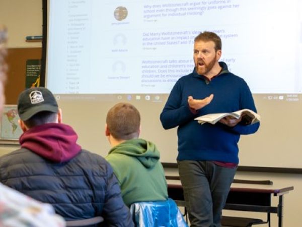 A faculty member delivers a lecture to students