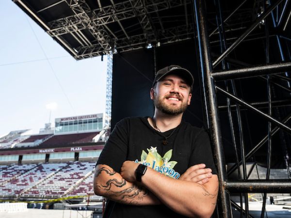 Marley Miller stands for a portrait on the stage built in Washington - Grizzly Stadium for the summer concert series