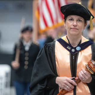Faculty Senate Chair Kimber McKay with Graduation Mace