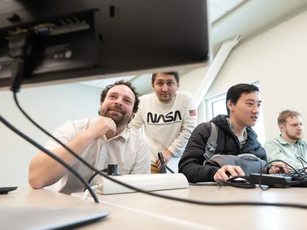 UM Students studying a laptop screen in the second annual Cyber, IT and CS Career Networking Event on the University of Montana Campus