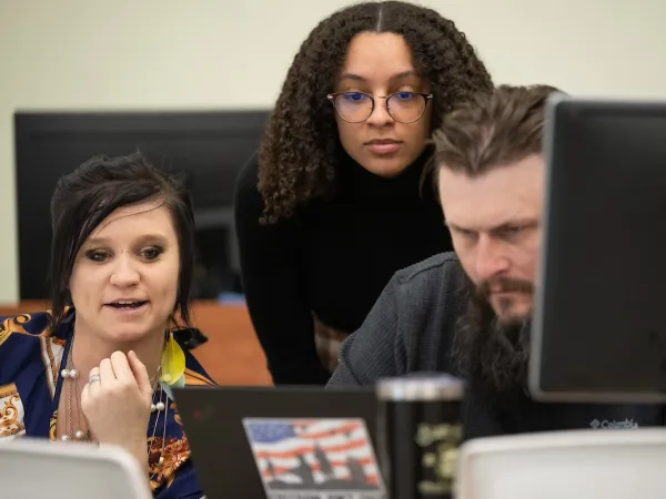 Students studying a laptop screen in the second annual Cyber, IT and CS Career Networking Event.