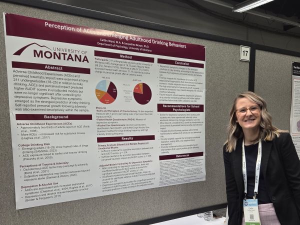 A graduate student presenting a poster at a conference