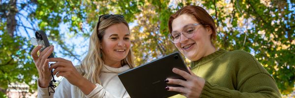 Two �Թ��� students enjoy having class outside, learning field and planning techniques used by geographers and planners on the UM campus on a spectacular Fall day.