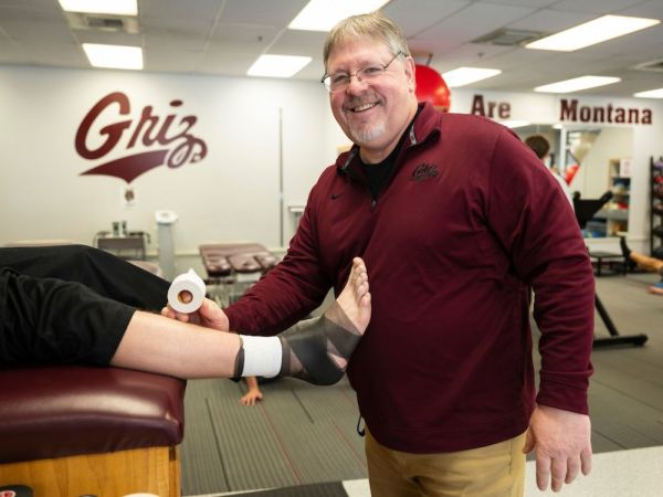 JC Weida, head athletic trainer at UM, works with an athlete