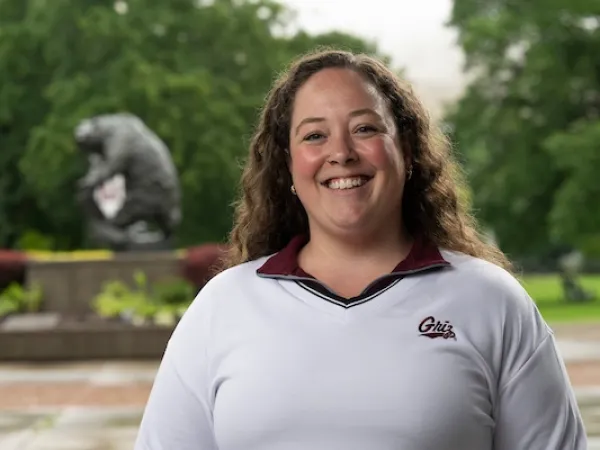 Brittany smiles for a portrait in front of the Grizzly Bear statue on the University of Montana campus.