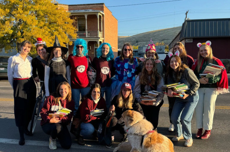 a group of costumed students and a sign for nsslha posing