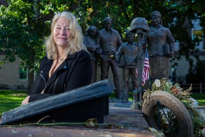 Photo of Cindi Laukes in front of veterans statue