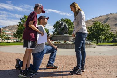 Andrew Pitsch proposes to Linsey Trenary on the University of Montana Oval Sept. 24 while her son, Landon, looks on. 