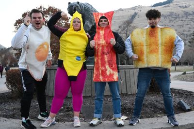 Students leaders dressed as food pose near the Grizzly Bear statue on campus.