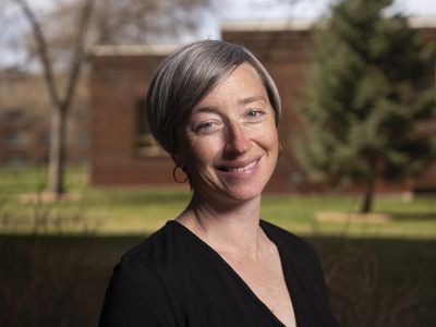 A portrait of a smiling female with short silver hair 