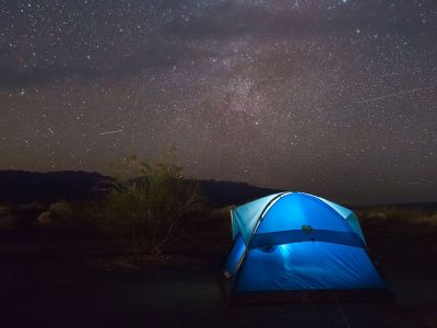 A tent glows under the stars.