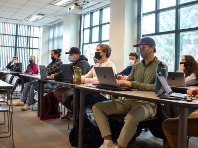 Masked UM College of Business students sit in a UM classroom