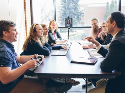 A picture of students and faculty members meeting around a table in the UM law school. 