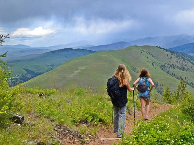 Two women hike down a trail on a mountain near Missoula.