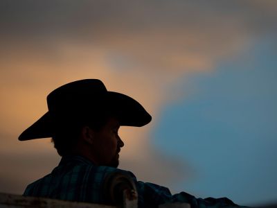 A silhouette of a cowboy at sunset.