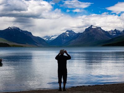 A man takes in the view from a lake in Glacier National Park.