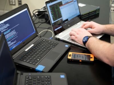 Photo of someone sitting at multiple laptops
